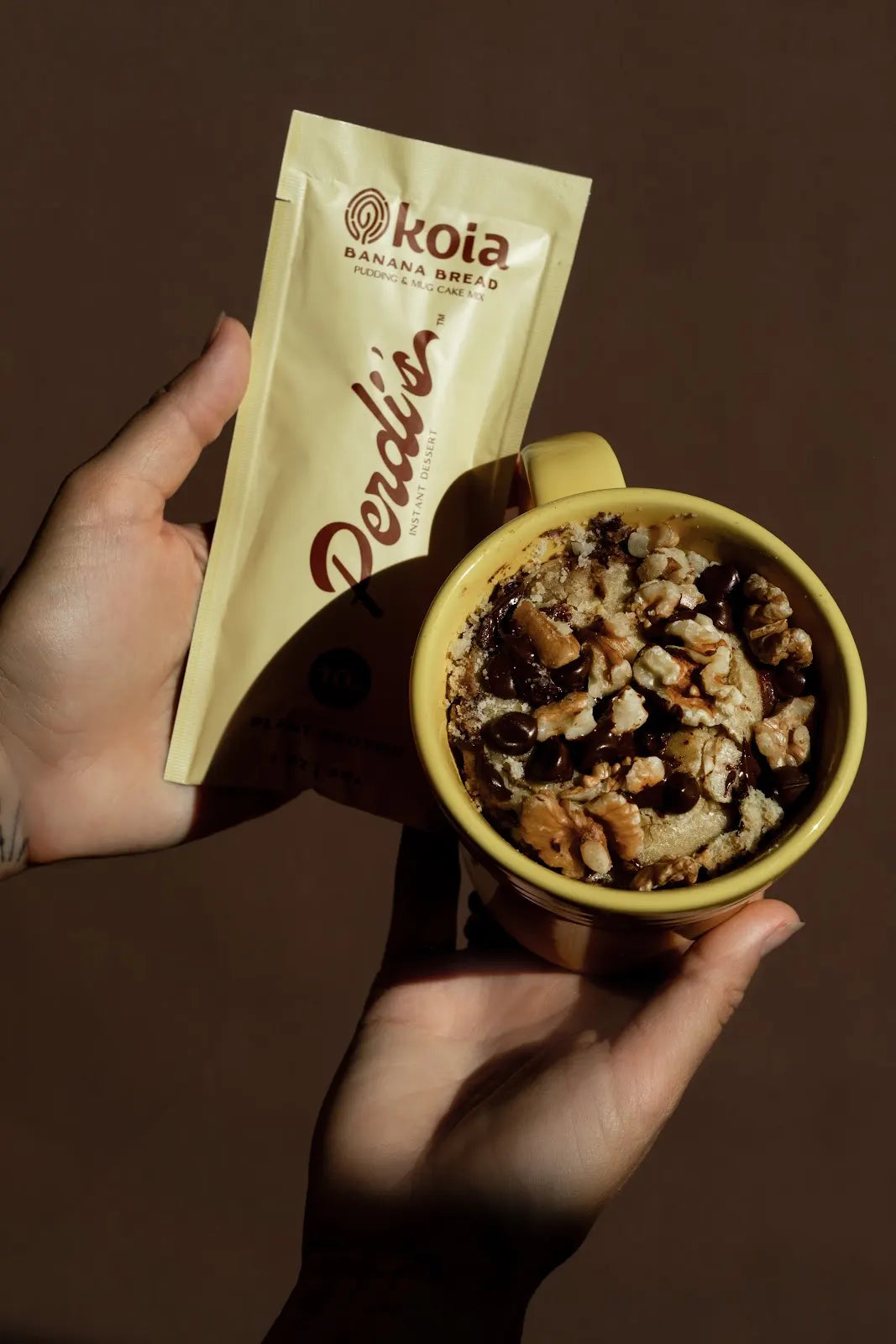 Hands holding a Banana Bread packet and mug cake