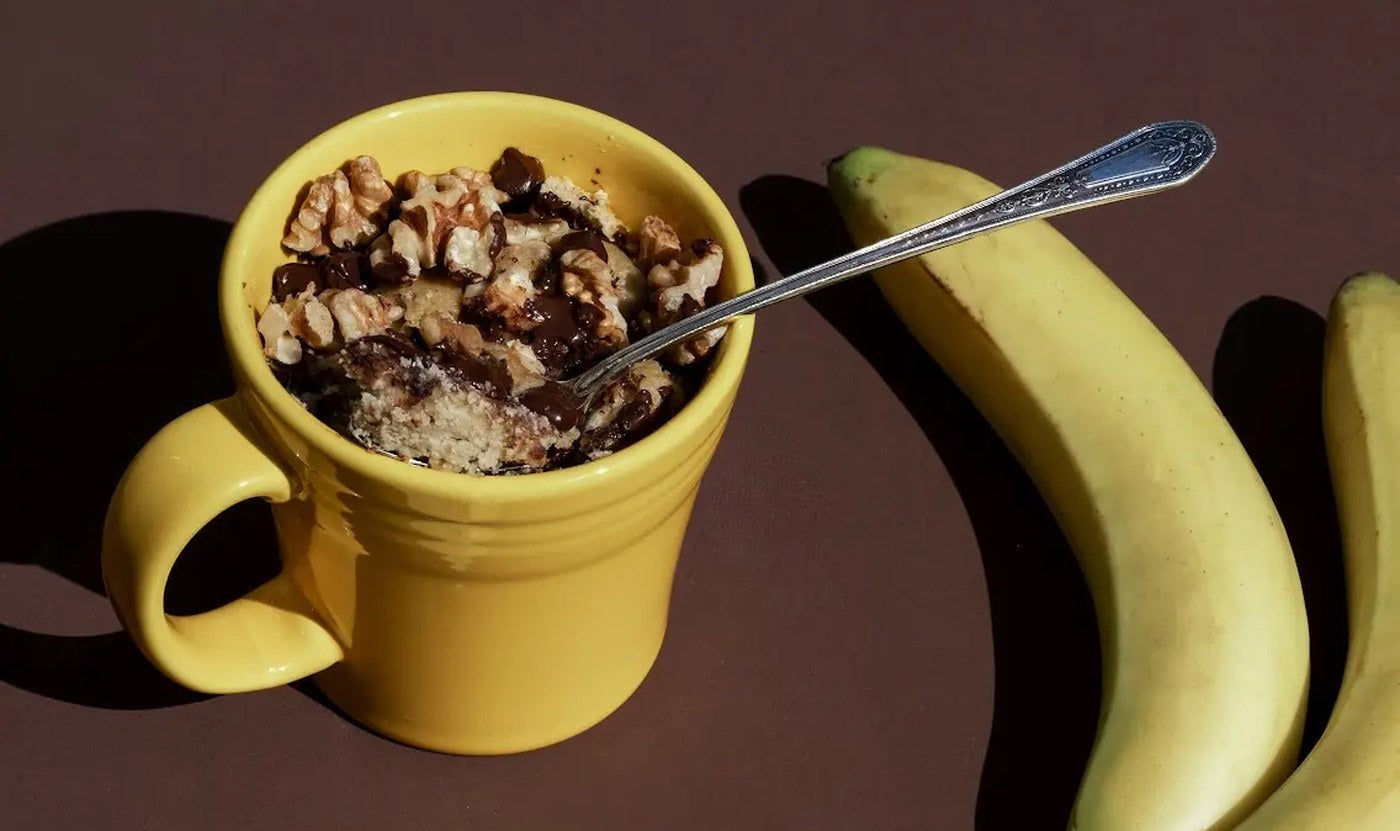 Banana Bread mug cake made with a Perdi's Banana Bread packet, beside bananas